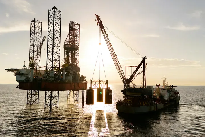 Jack-up drilling rig at sea with a supply vessel alongside